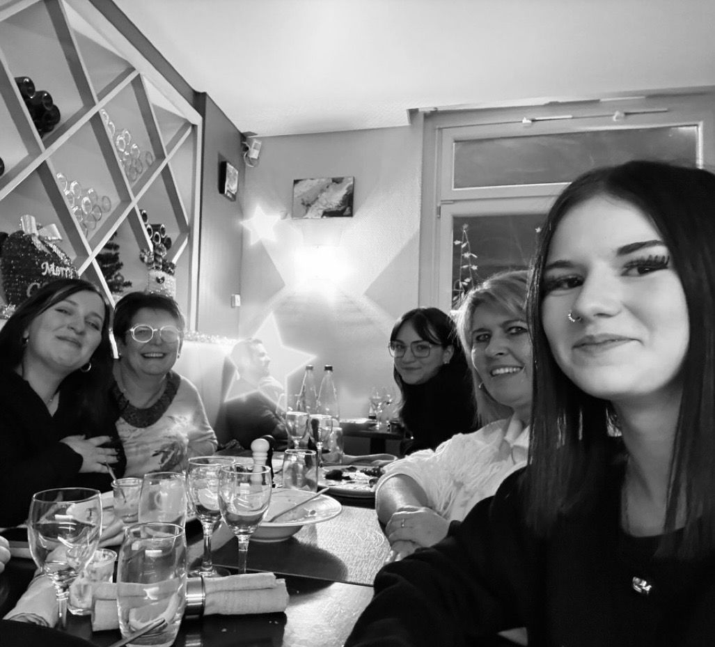 L'équipe du salon Coiffurama dans un restaurant ; verres, assiettes et un mur décoratif.