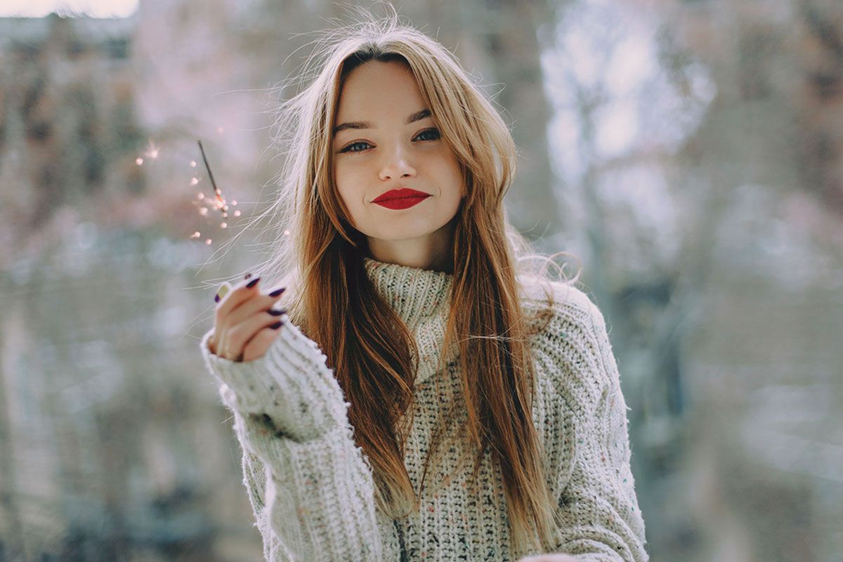 Une femme qui tient une bougie à étincelles