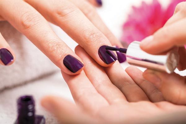 Une main qui se fait peindre les ongles