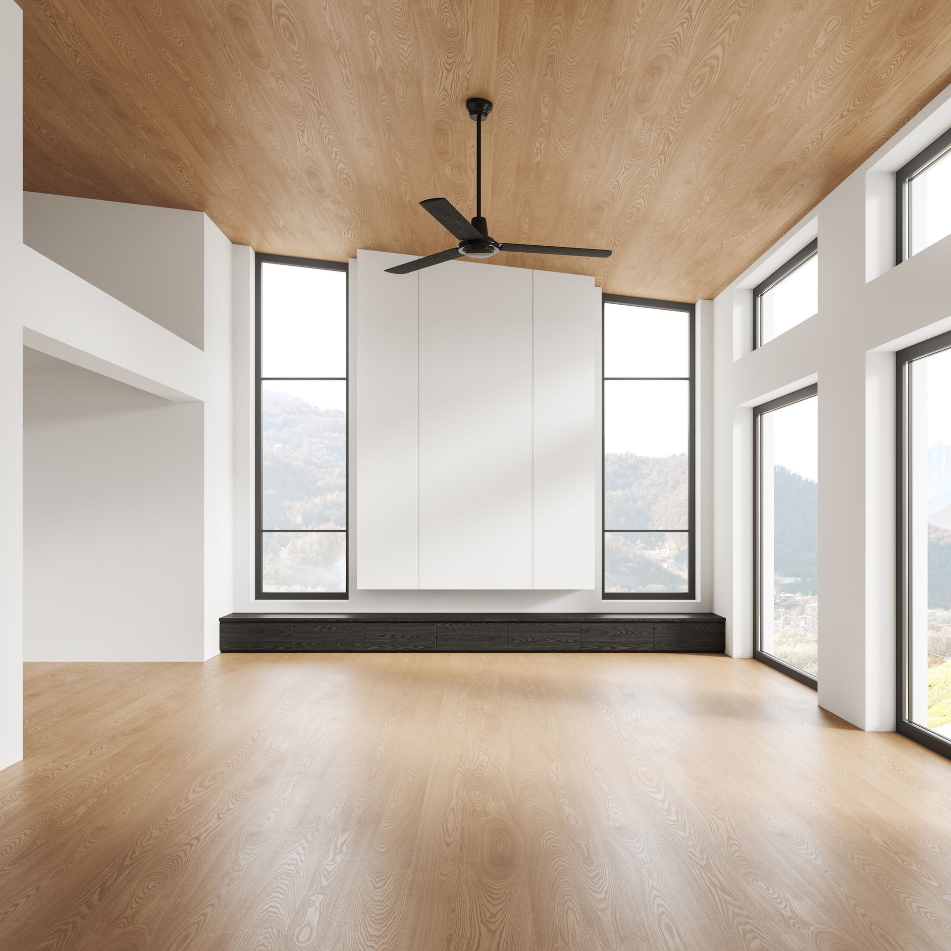 Una habitación vacía con un ventilador de techo y muchas ventanas.