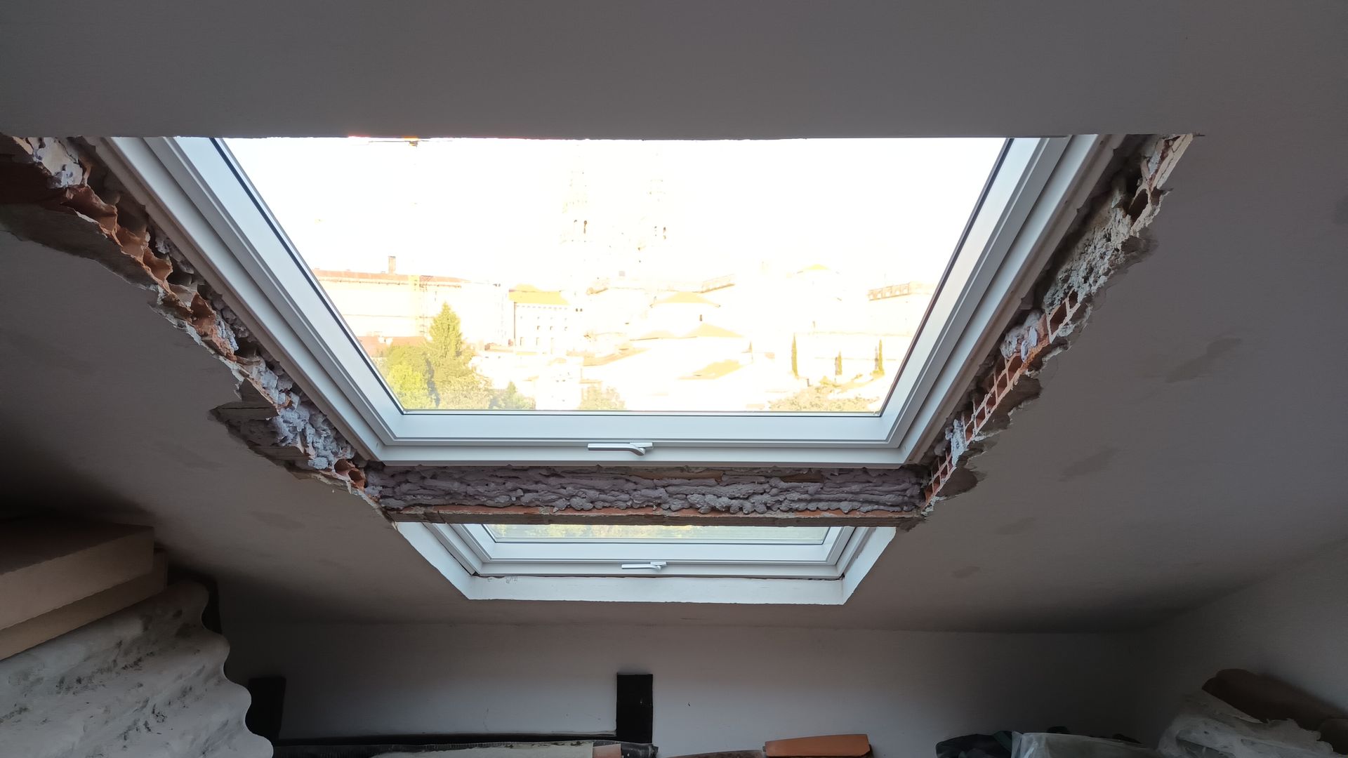 Dos claraboyas rectangulares en un techo. El yeso circundante está dañado.