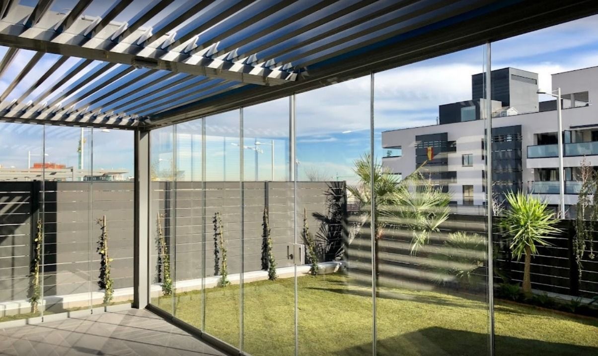 Un patio con pérgola y puertas corredizas de vidrio.