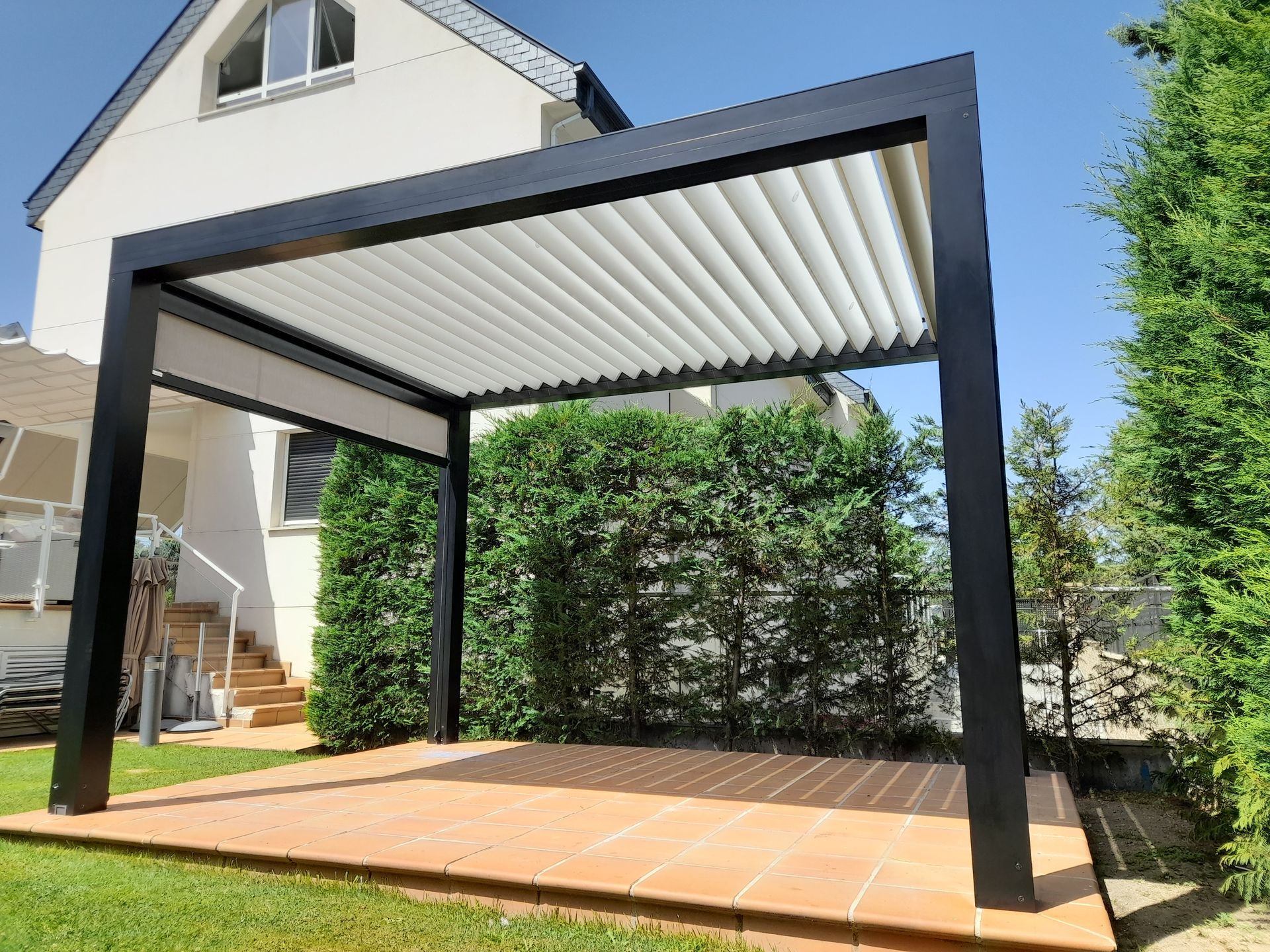 Hay una pérgola en el patio trasero de una casa.
