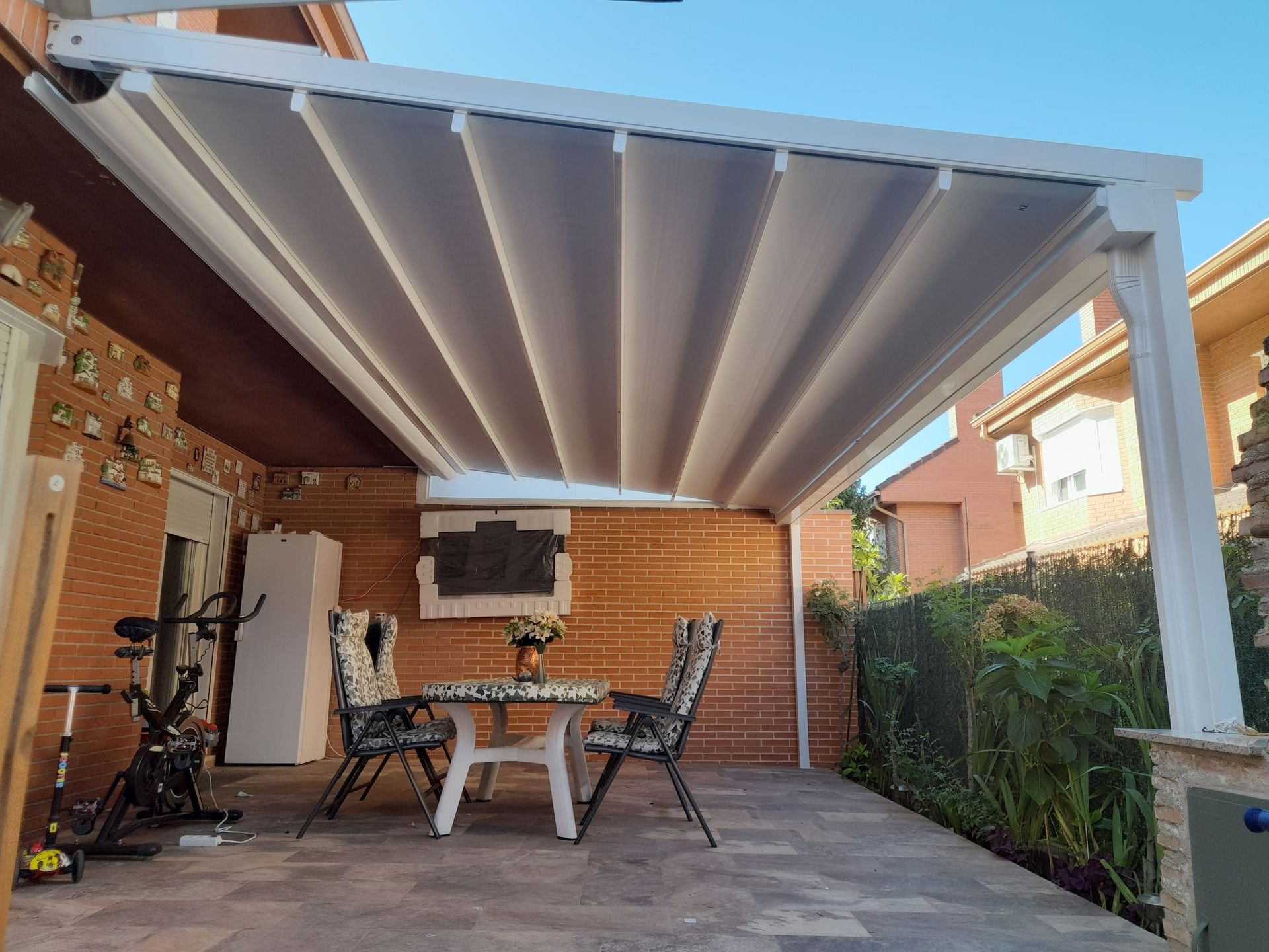 Un patio con una mesa y sillas bajo un dosel.