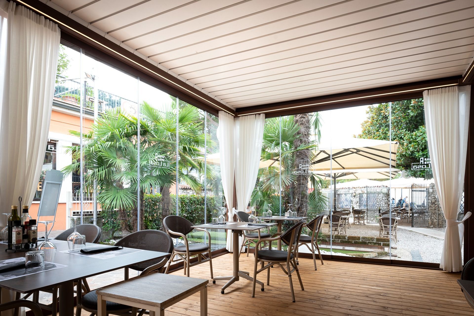 Un restaurante con mesas y sillas bajo un dosel.