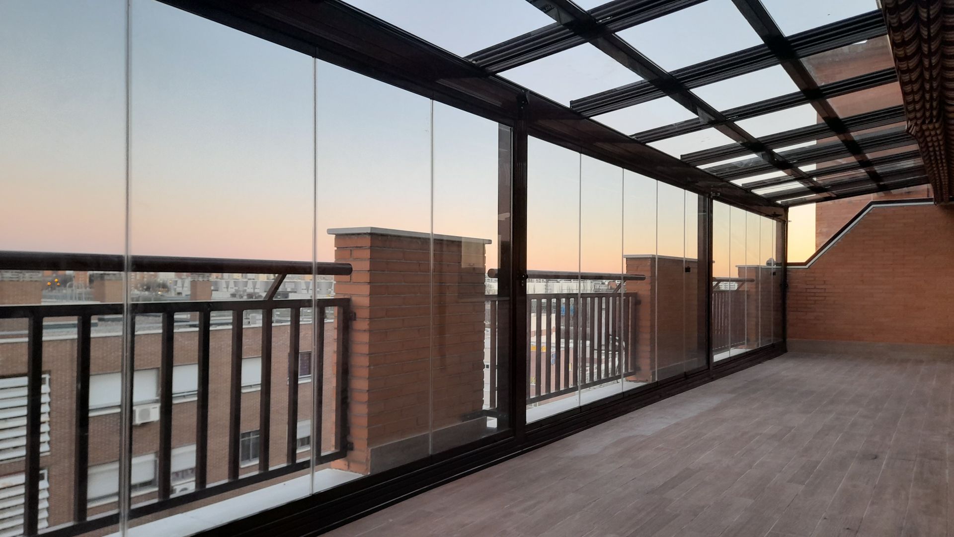 Un balcón vacío con puertas corredizas de vidrio y barandilla.