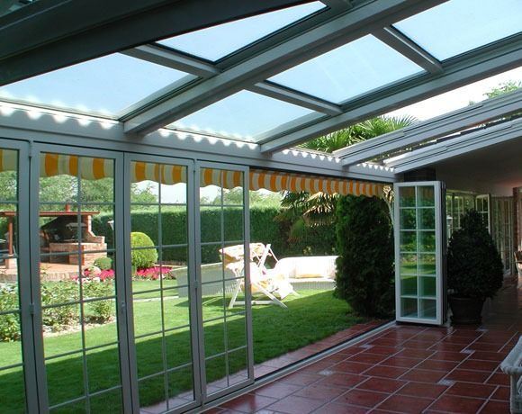 Una habitación con muchas ventanas y un toldo amarillo y blanco.