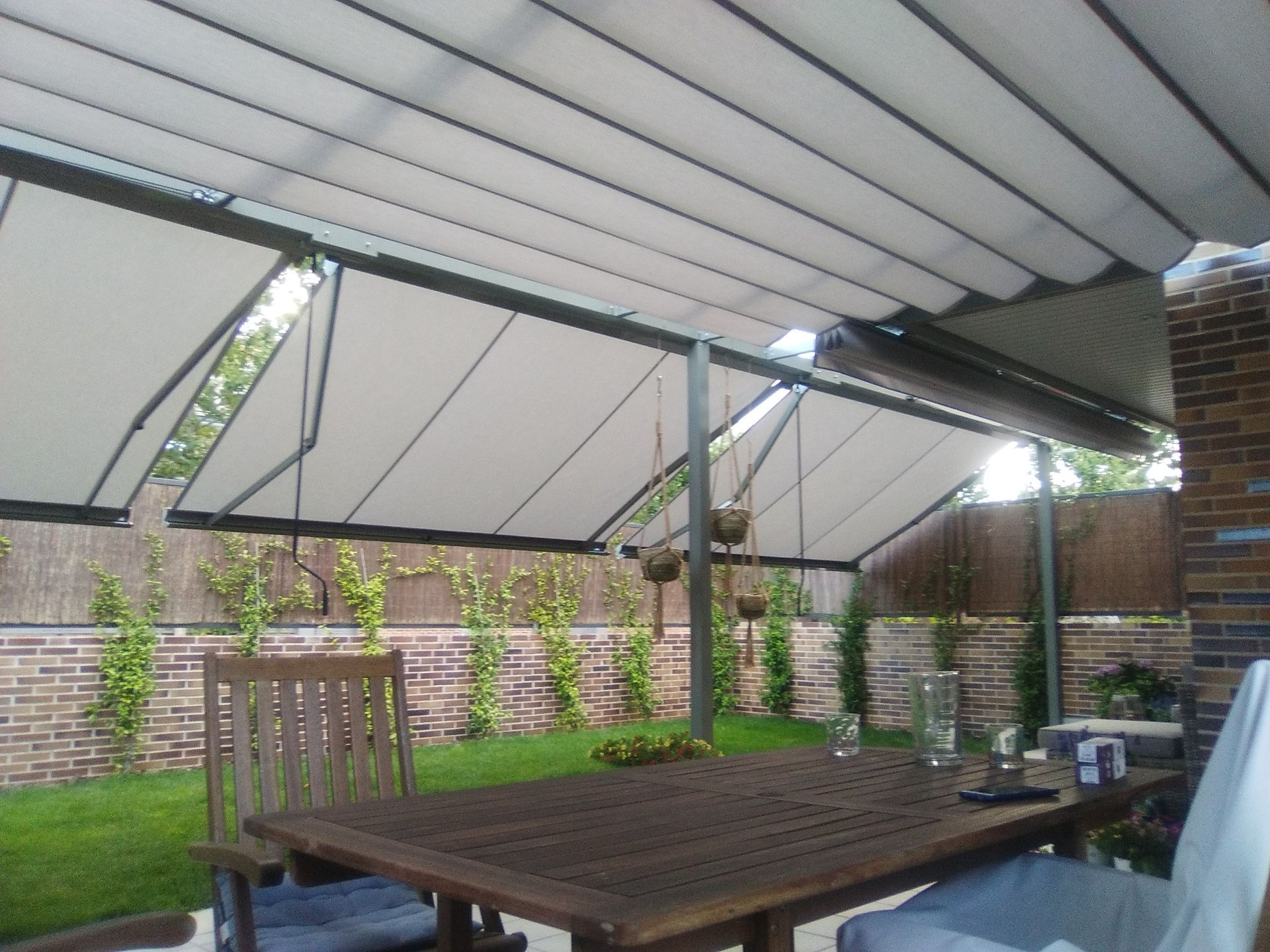 Un patio con una mesa y sillas bajo un toldo.