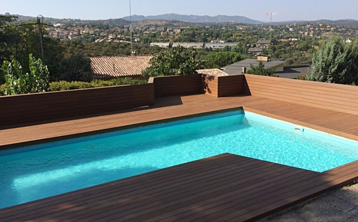 Una gran piscina está rodeada por una terraza de madera.
