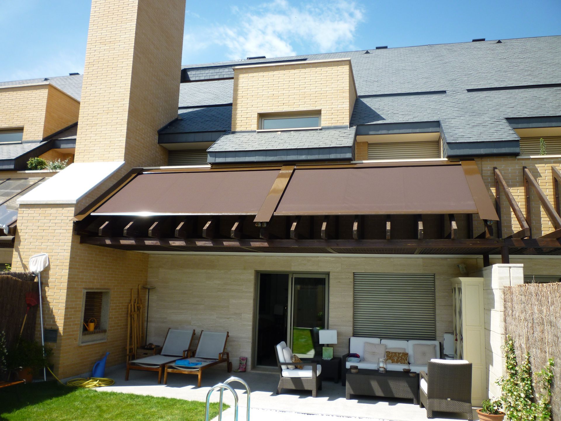 Una casa con un toldo marrón sobre un área de patio.