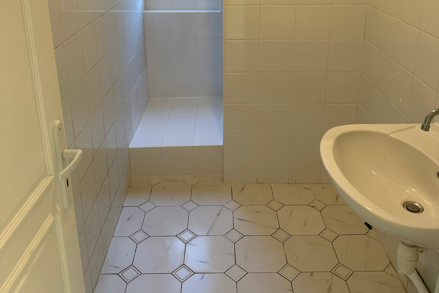 Une salle de bain avec lavabo, WC et douche.