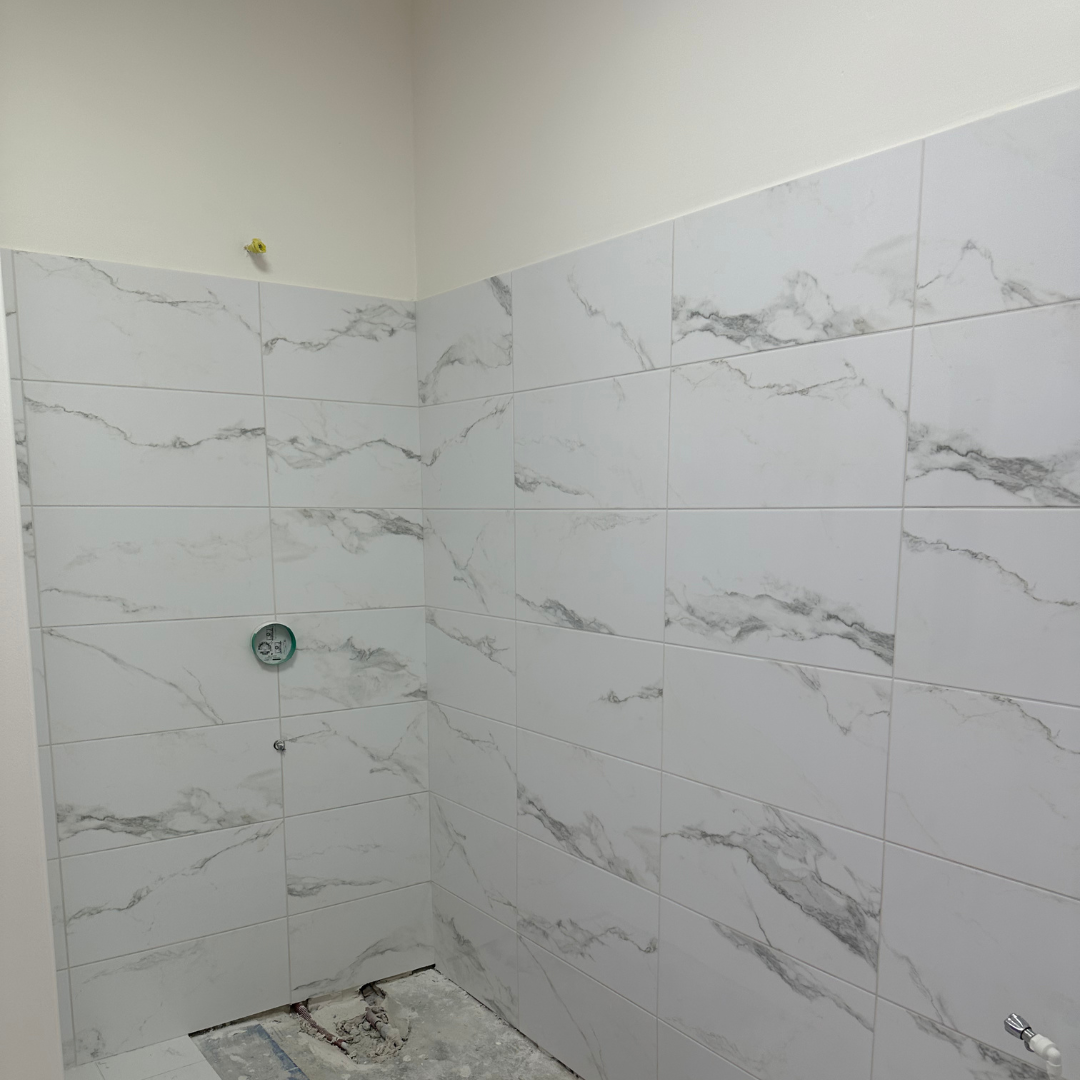 Une pièce vide avec un mur blanc et une porte.