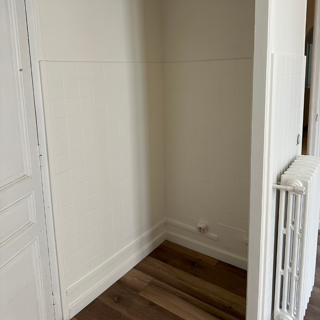 Une cuisine vide avec des armoires blanches et une cuisinière