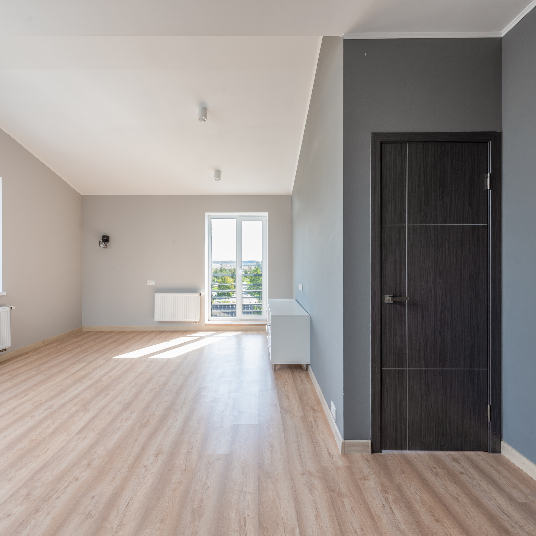Un salon vide avec une porte coulissante en verre et une cheminée.