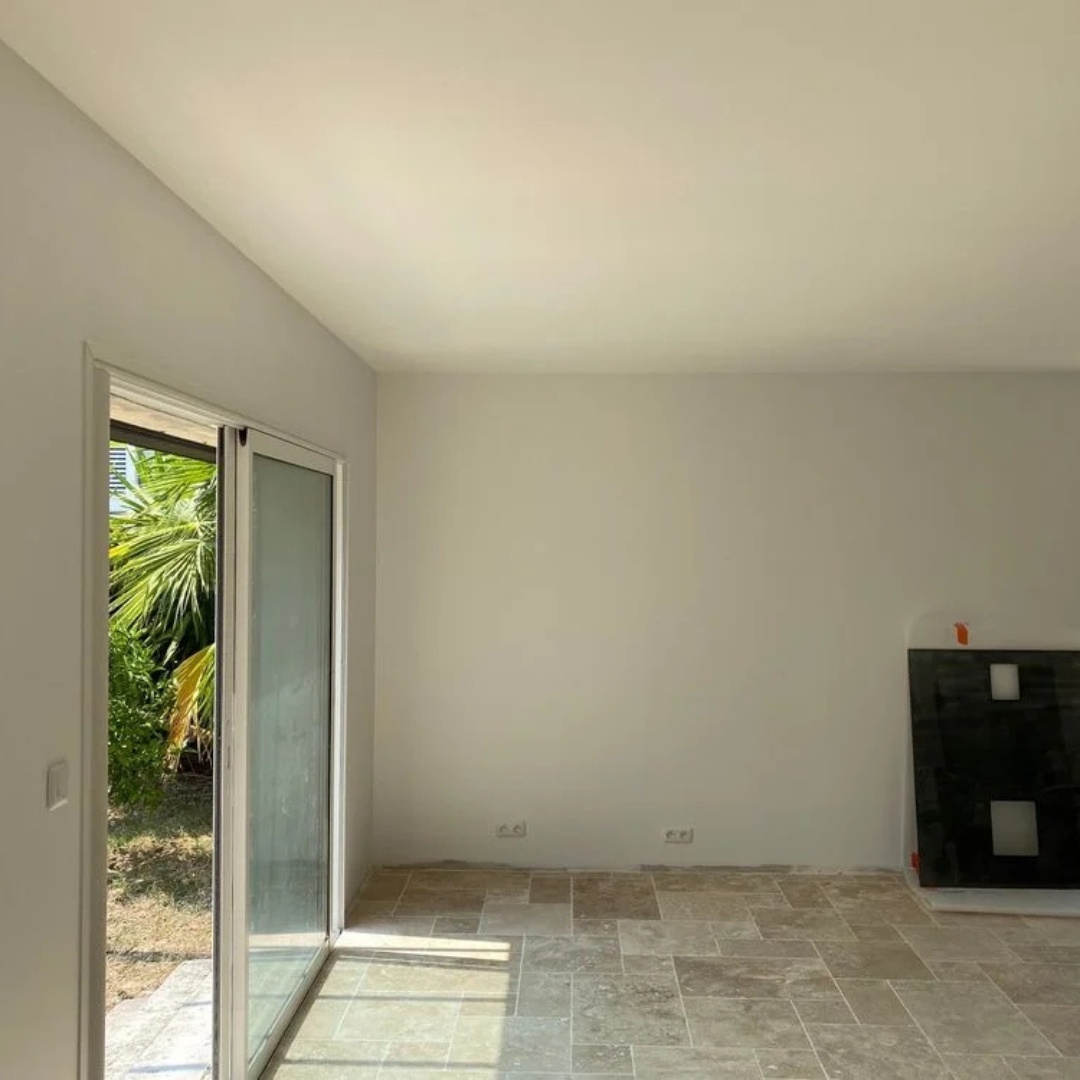 Un salon vide avec une porte coulissante en verre et une cheminée.