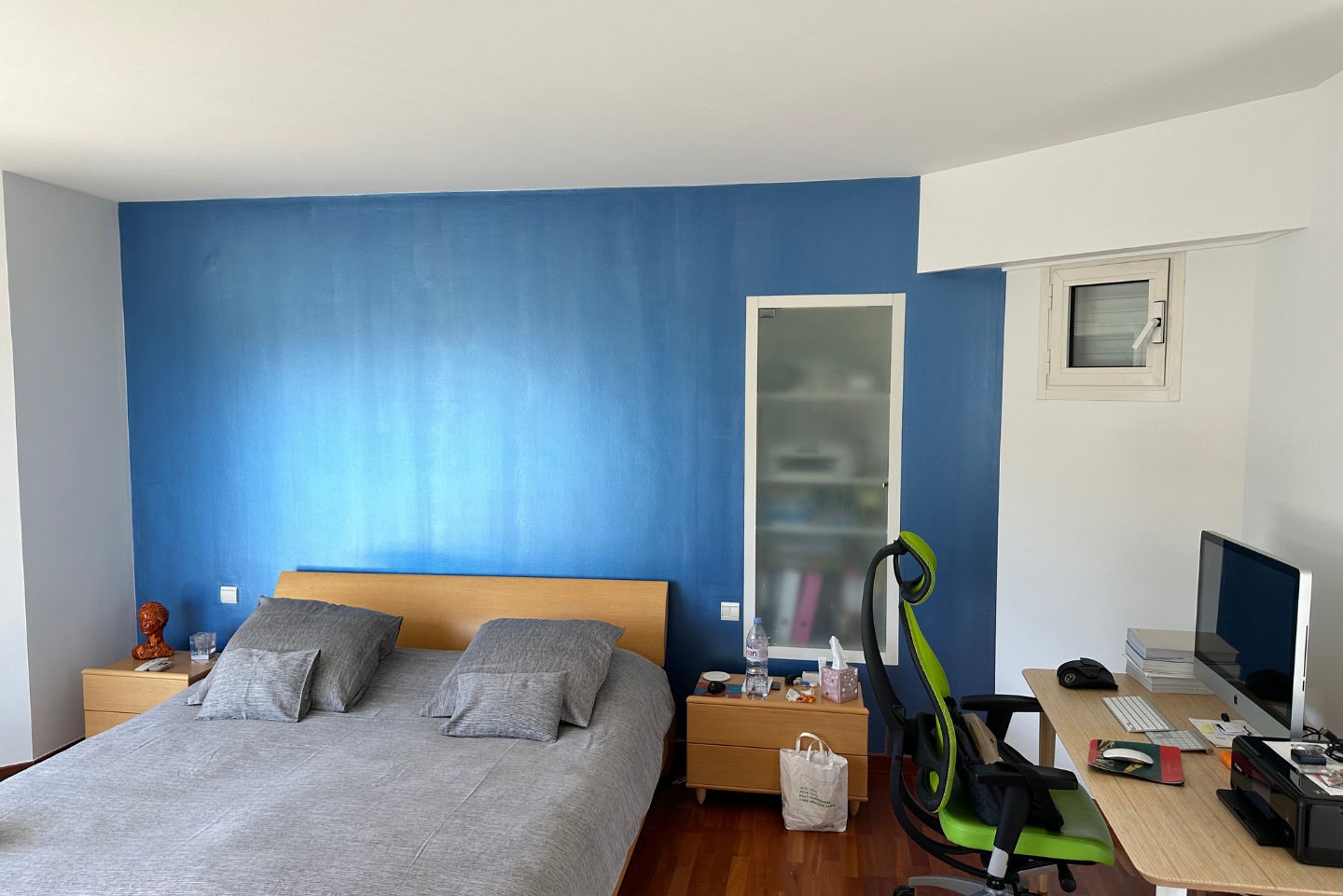 Une chambre avec un lit et un bureau avec un ordinateur dessus