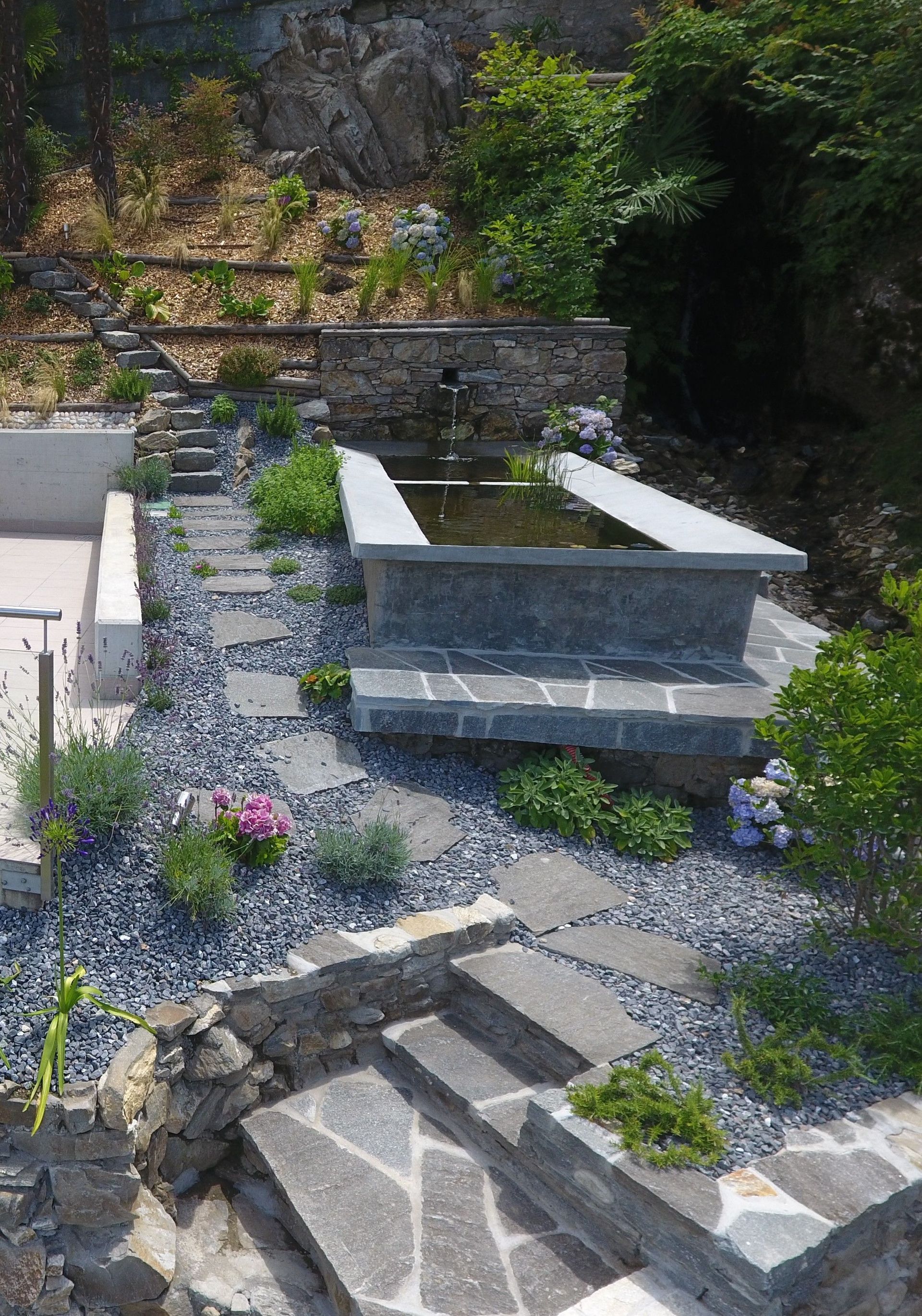 Garten mit Steinen, Schieferfliesen und Bäumen