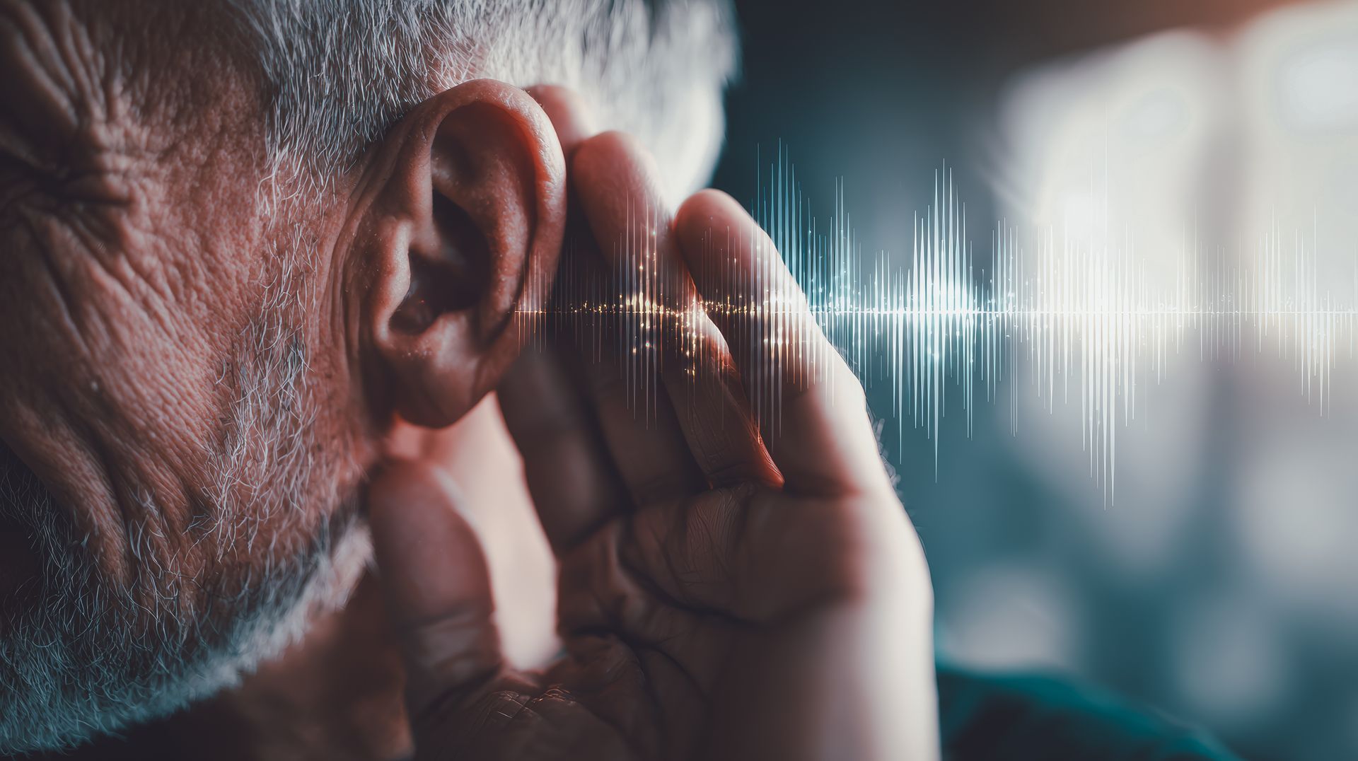 Personne se tenant l'oreille en coupe, avec une onde sonore blanche superposée sur un fond sombre et flou.