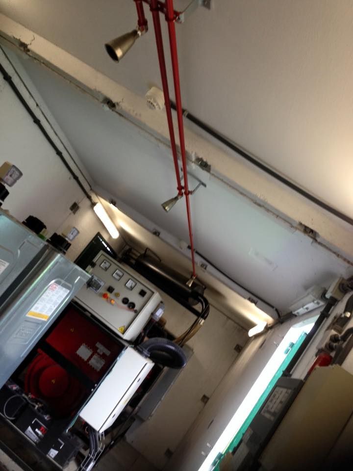 Una habitación con una tubería roja colgando del techo.