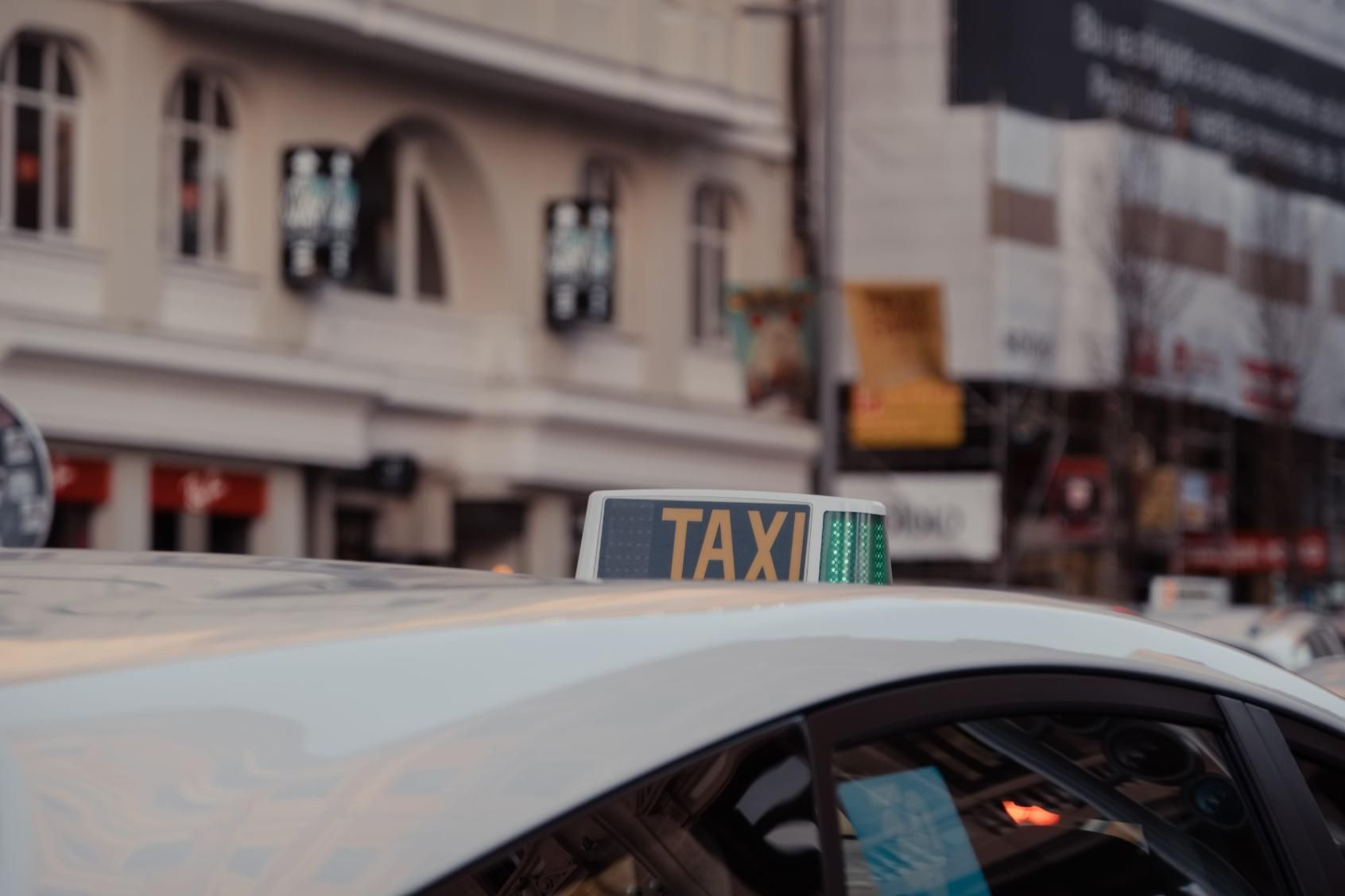 Letrero de taxi en el techo de un coche en una escena callejera de la ciudad