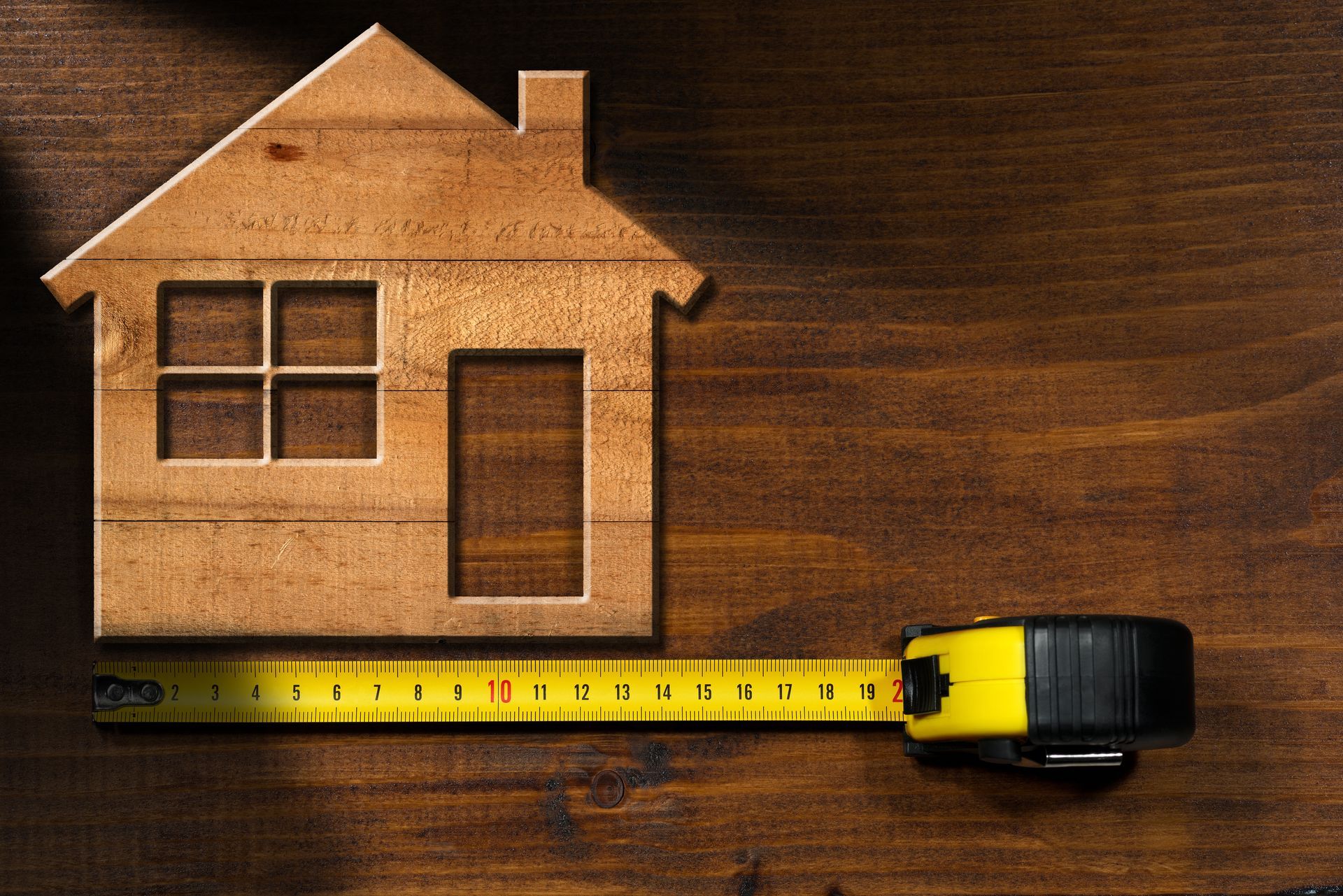 Maison miniature en bois avec porte, fenêtre et mètre de mesures