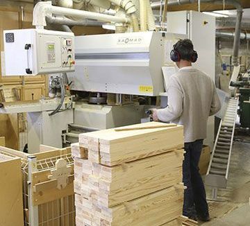 Menuisier devant une machine outil à l'atelier