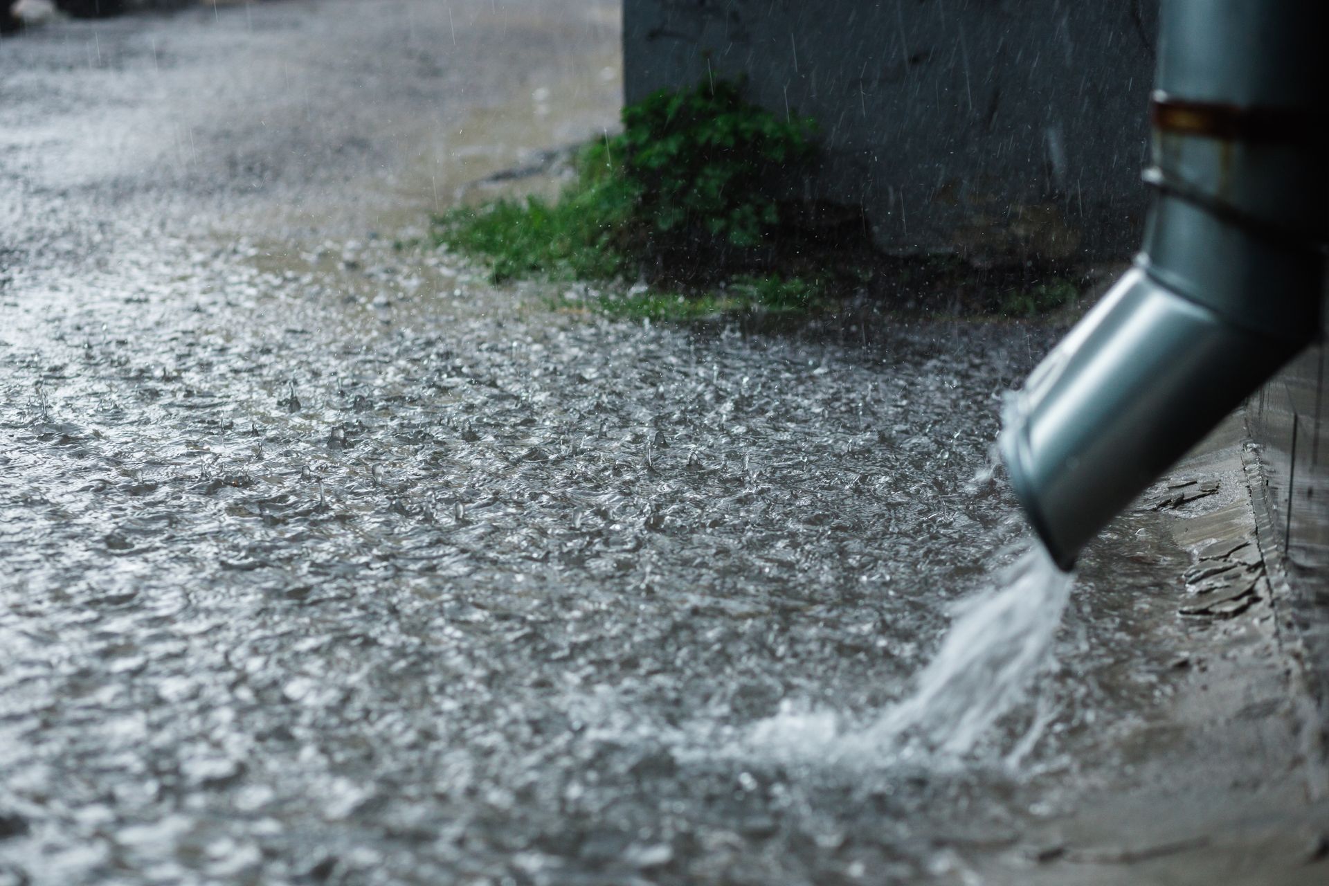 Gouttière déversant l'eau de pluie dans la rue