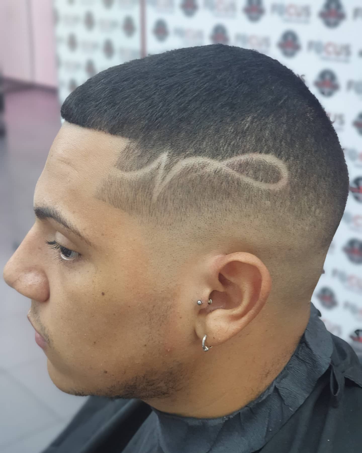 Hombre con corte de pelo descolorido y diseño grabado en el costado de la cabeza.