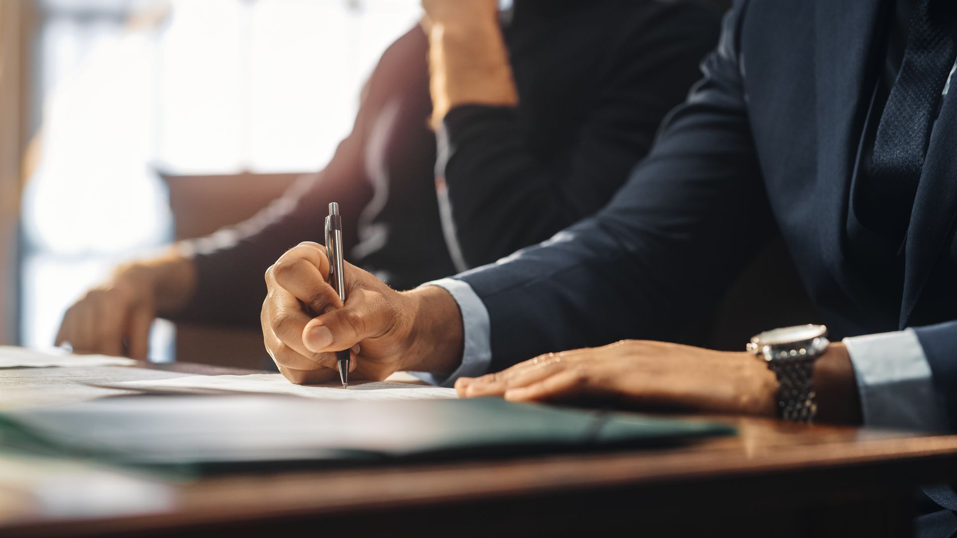 Une personne signant un document à un bureau dans un environnement de bureau