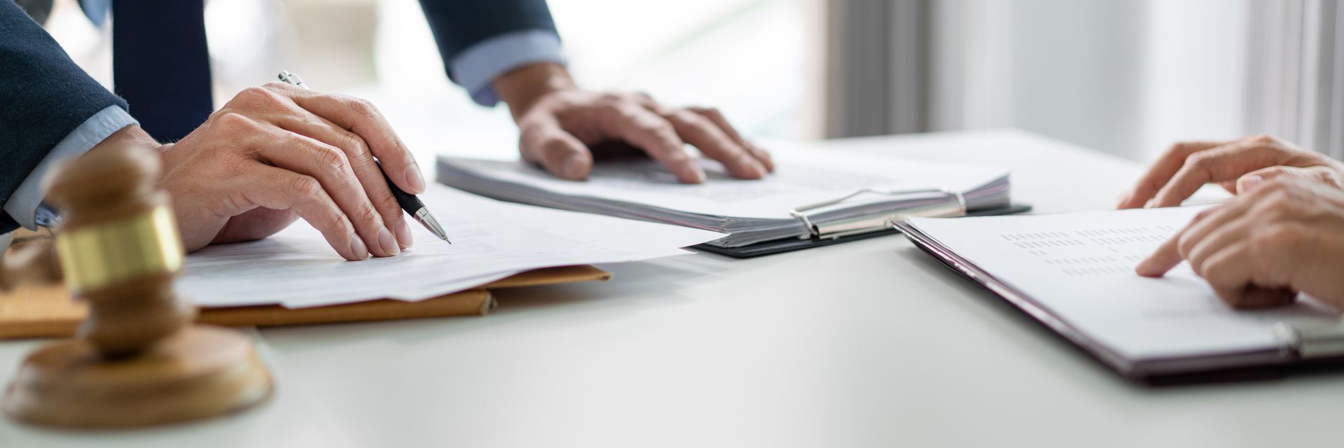 Réunion d'affaires : documents, tablette et maillet posés sur une table de conférence.