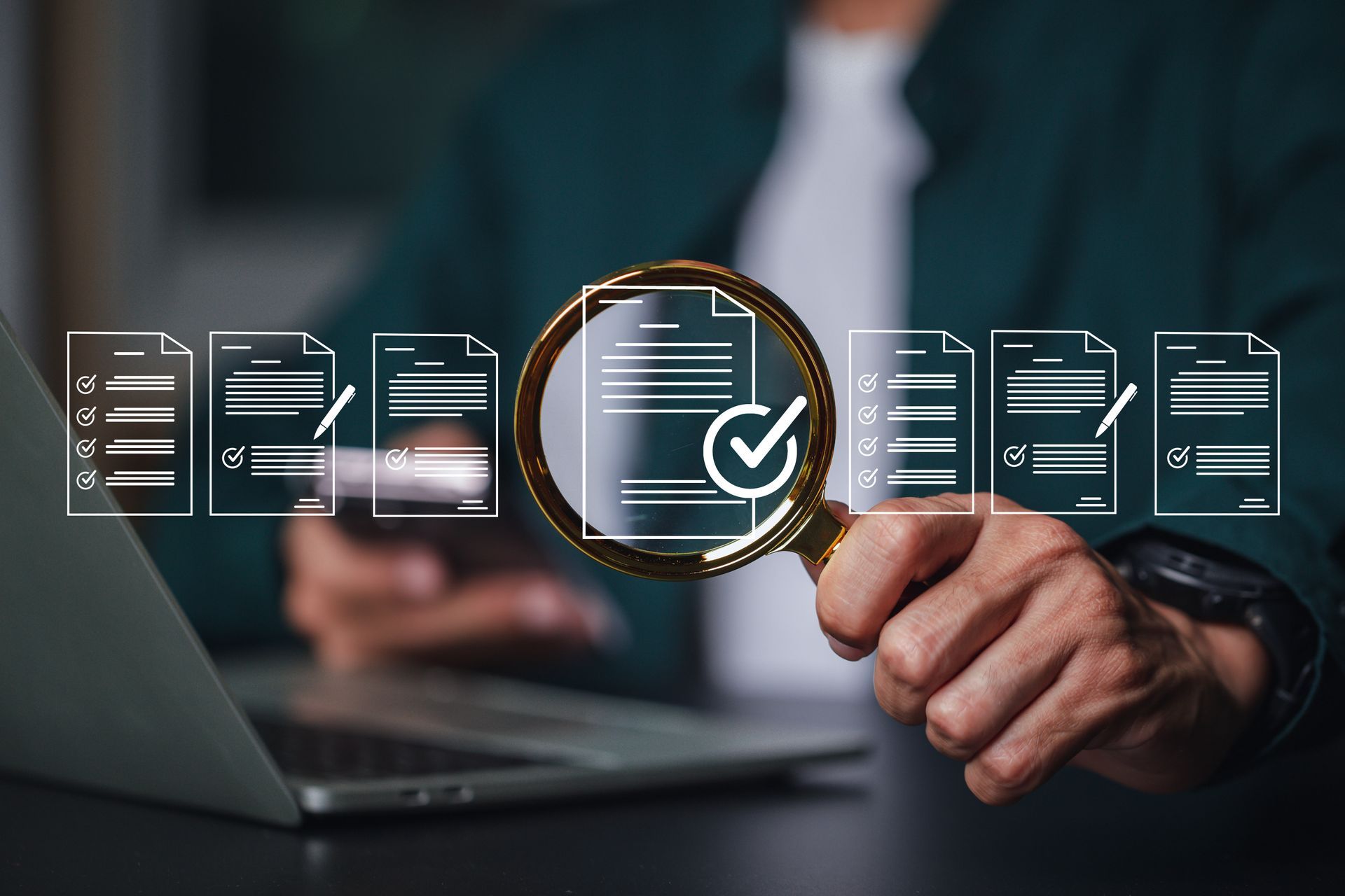 Des mains manipulant un ordinateur portable et une loupe sur des icônes de liste de contrôle suggèrent une révision ou une vérification de documents.