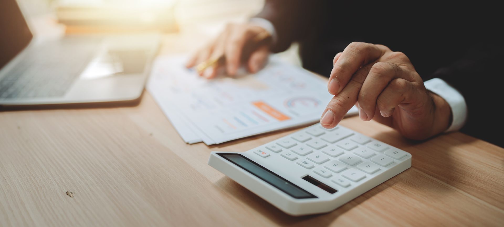 Une personne utilisant une calculatrice blanche.