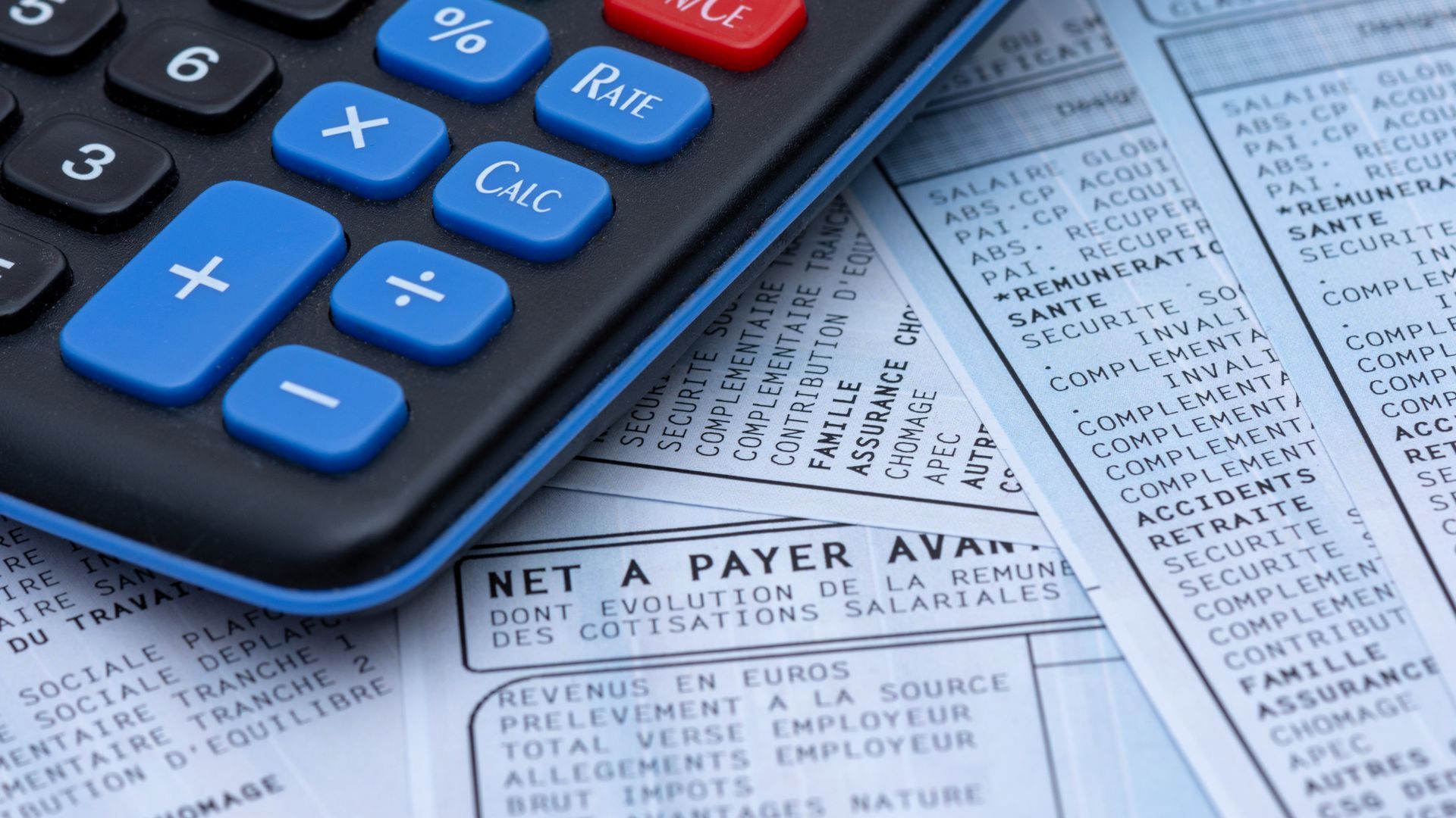Une calculatrice sur des bulletins de paies.
