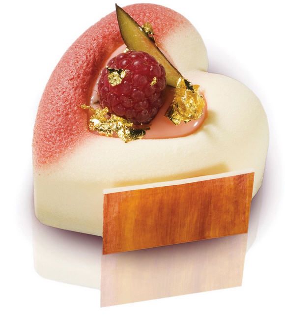 Ein herzförmiges Dessert mit einer Himbeere obendrauf