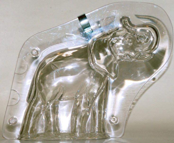 Auf einem Tisch steht die durchsichtige Plastikform eines Elefanten.