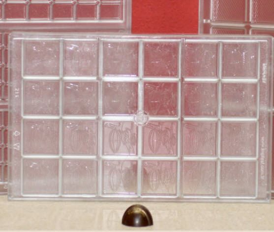 Eine durchsichtige Schokoladenform aus Kunststoff mit einer Schokolade darin