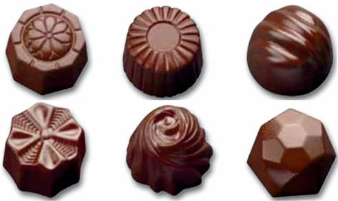 Sechs verschieden geformte Pralinen sind auf einem weißen Hintergrund aufgereiht