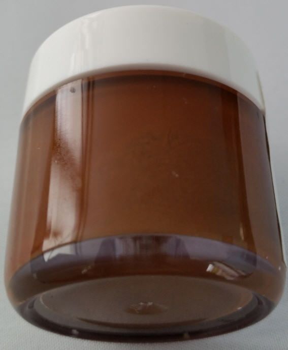 Ein braunes Glasgefäß mit weißem Deckel