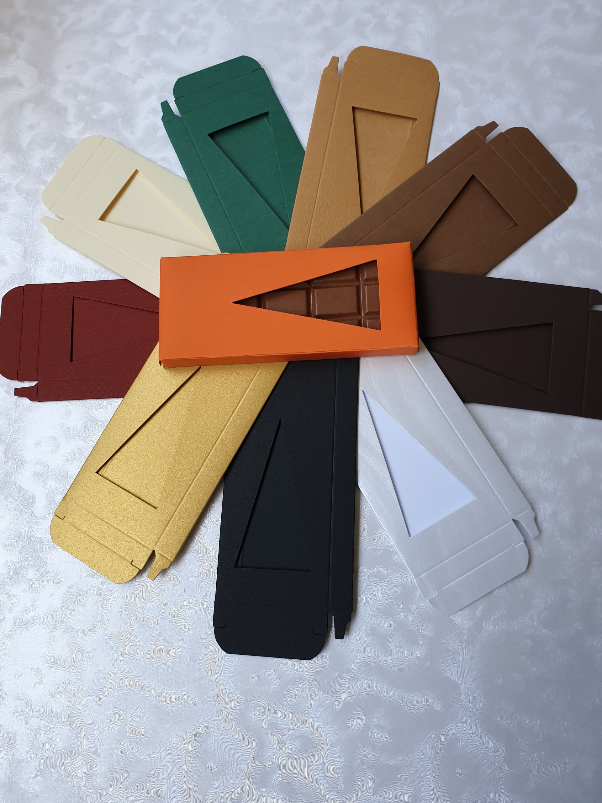 Ein Haufen verschiedenfarbiger Kartons mit einer Tafel Schokolade in der Mitte