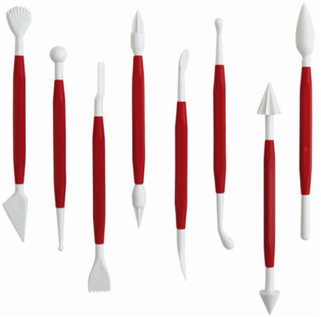 Ein Satz Dekorationswerkzeuge aus Kunststoff mit roten Griffen auf weißem Hintergrund.