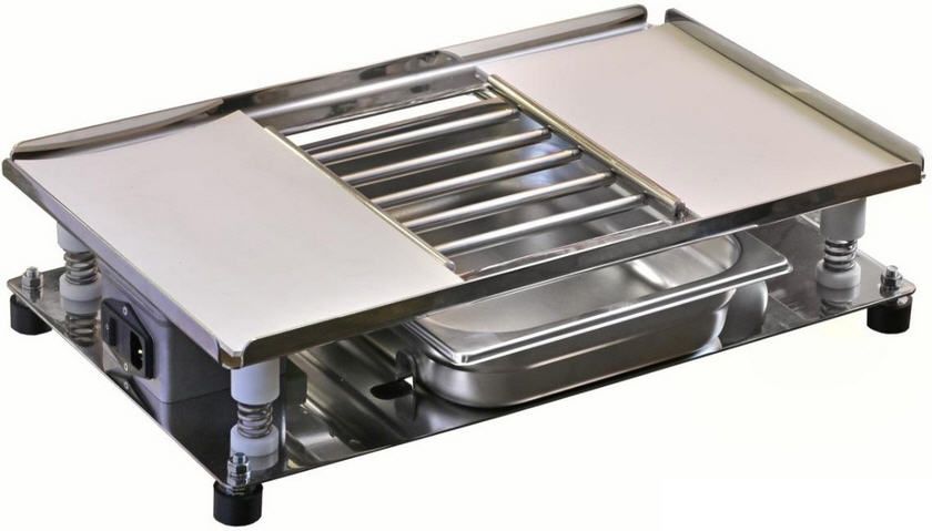 Ein Herd aus Edelstahl mit einem Tablett darauf.