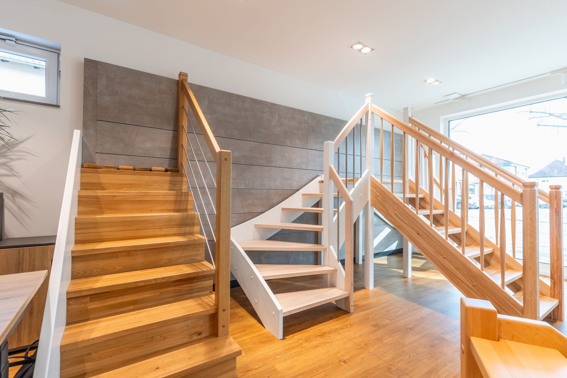 Ein Raum mit Holztreppe und weißem Geländer.