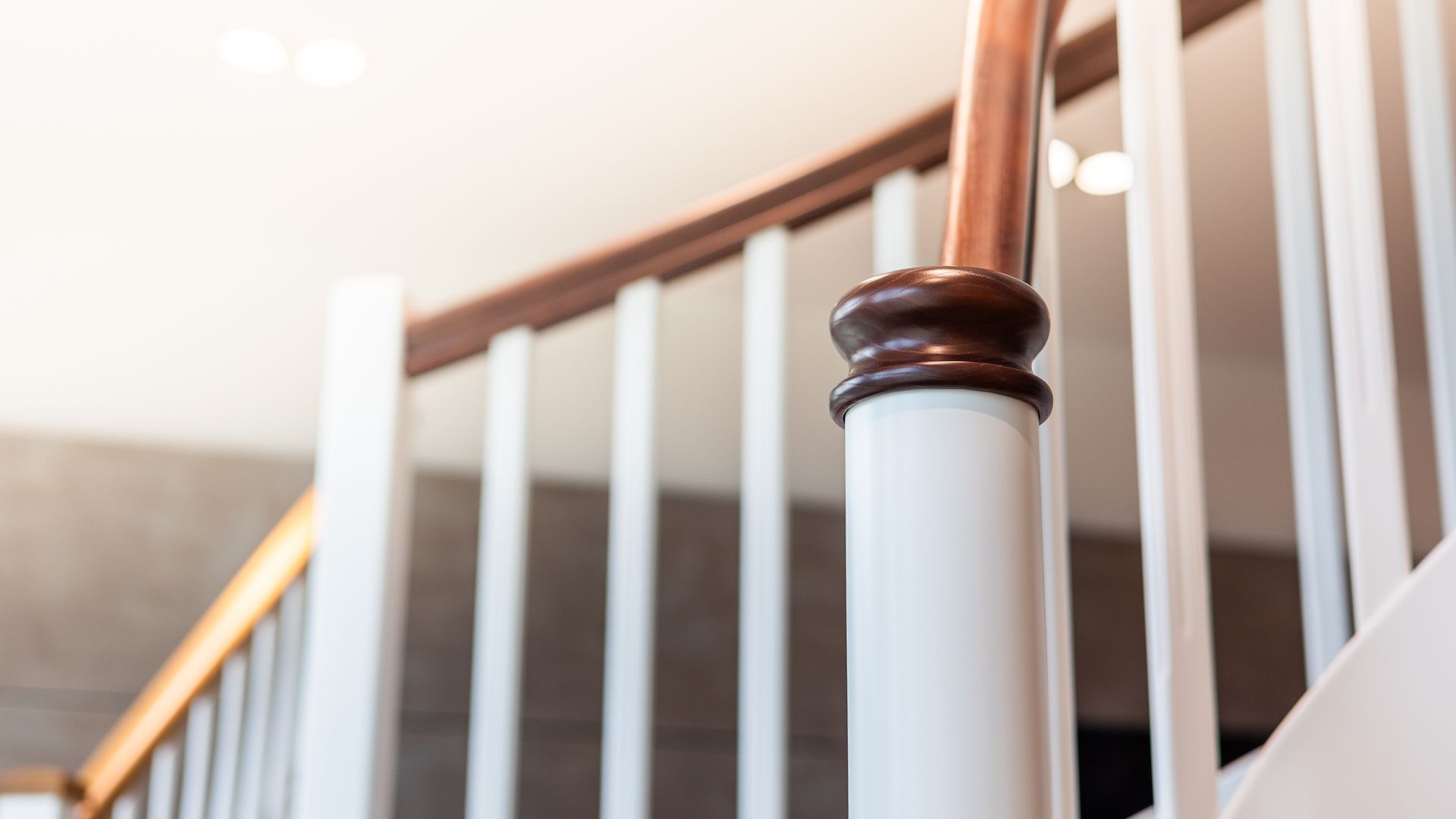 Eine Nahaufnahme eines Holzgeländers auf einer weißen Treppe.