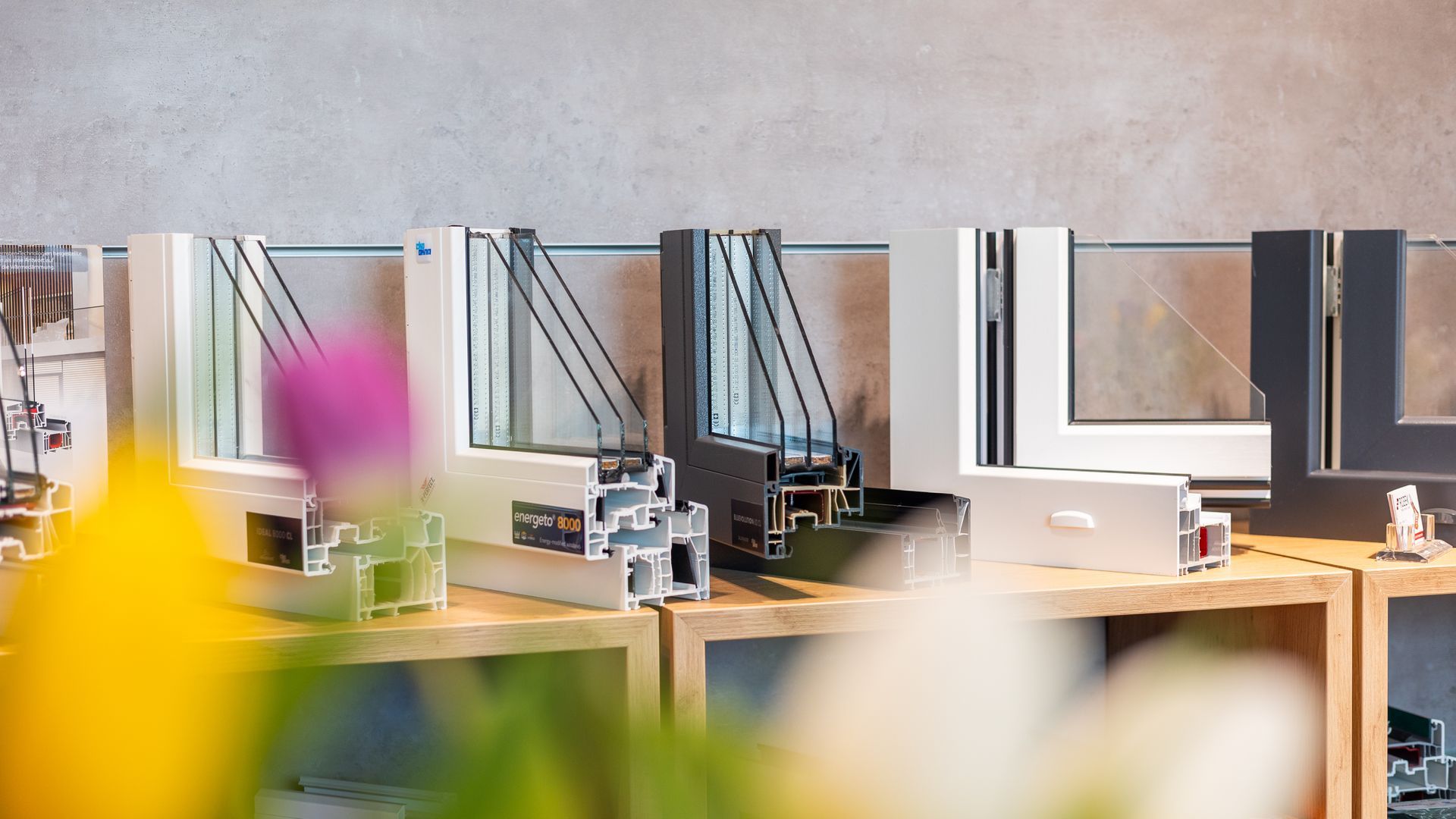 Auf einem Tisch sind viele unterschiedliche Fenstertypen ausgestellt.