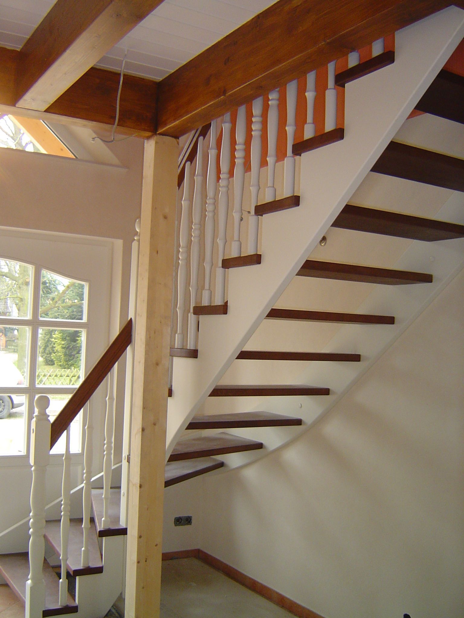 Eine Treppe mit Holzstufen und weißem Geländer