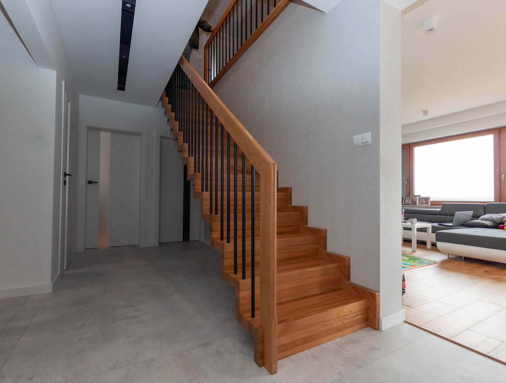 Eine Holztreppe mit einem Metallgeländer in einem Flur eines Hauses.