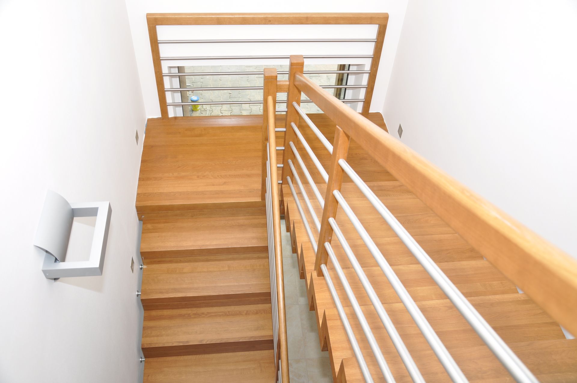 Eine Holztreppe mit Metallgeländer führt in den zweiten Stock