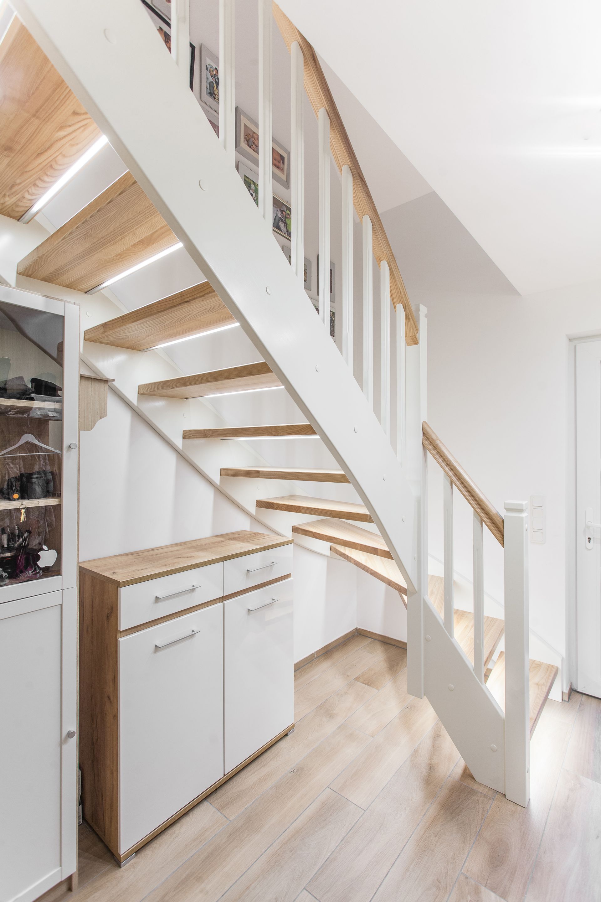 Eine Treppe mit Holzstufen und einem weißen Geländer in einem Raum.