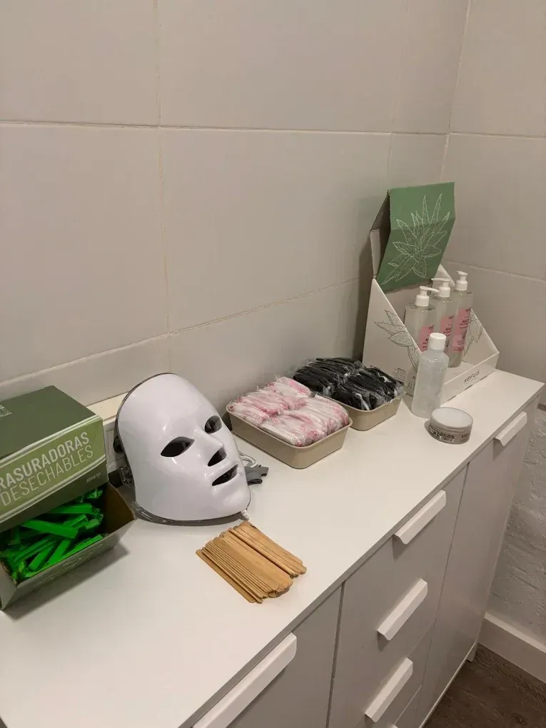Estación de cuidado de la piel blanca con máscara LED, productos y suministros.