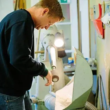 Ein konzentrierter Mann bedient eine Holzbearbeitungsmaschine.